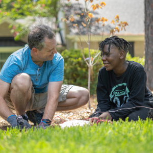 A counselor doing gardening with a student