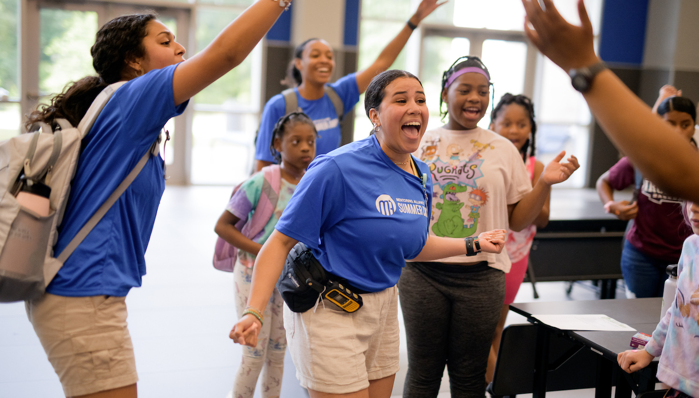 A summer camp counselor getting the kids excited